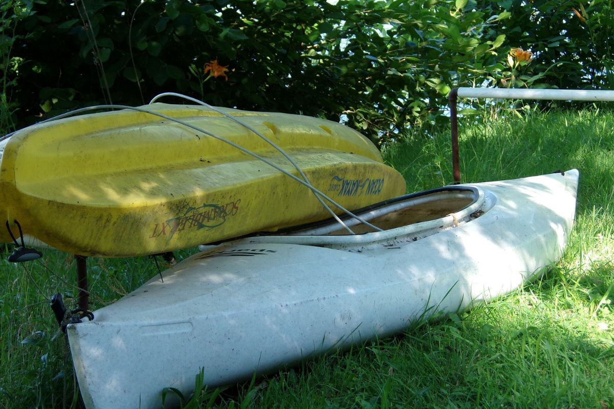 Two dirty kayaks out in the sun