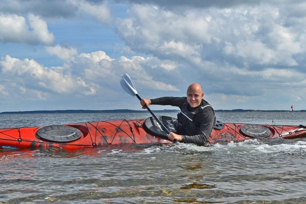 Person riding a kayak performing an eskimo roll