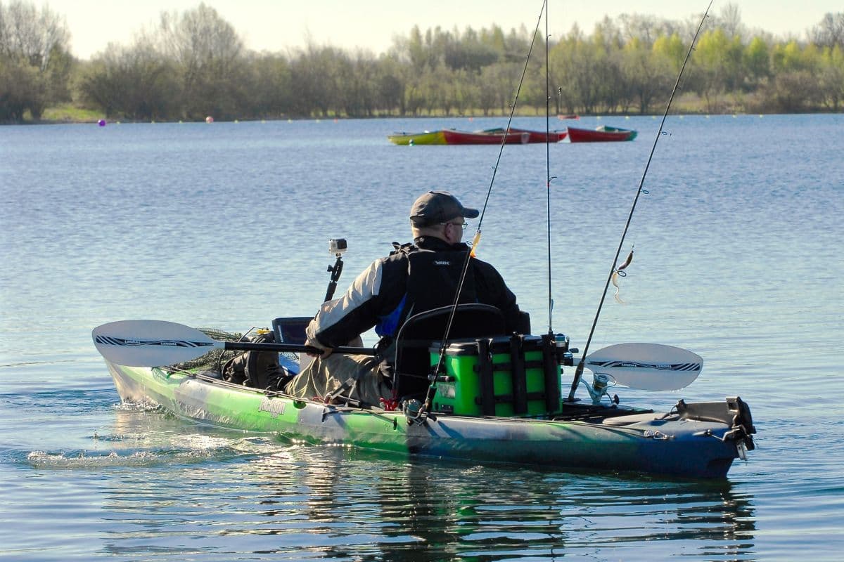 Man riding a kayak bringing fishing equipment