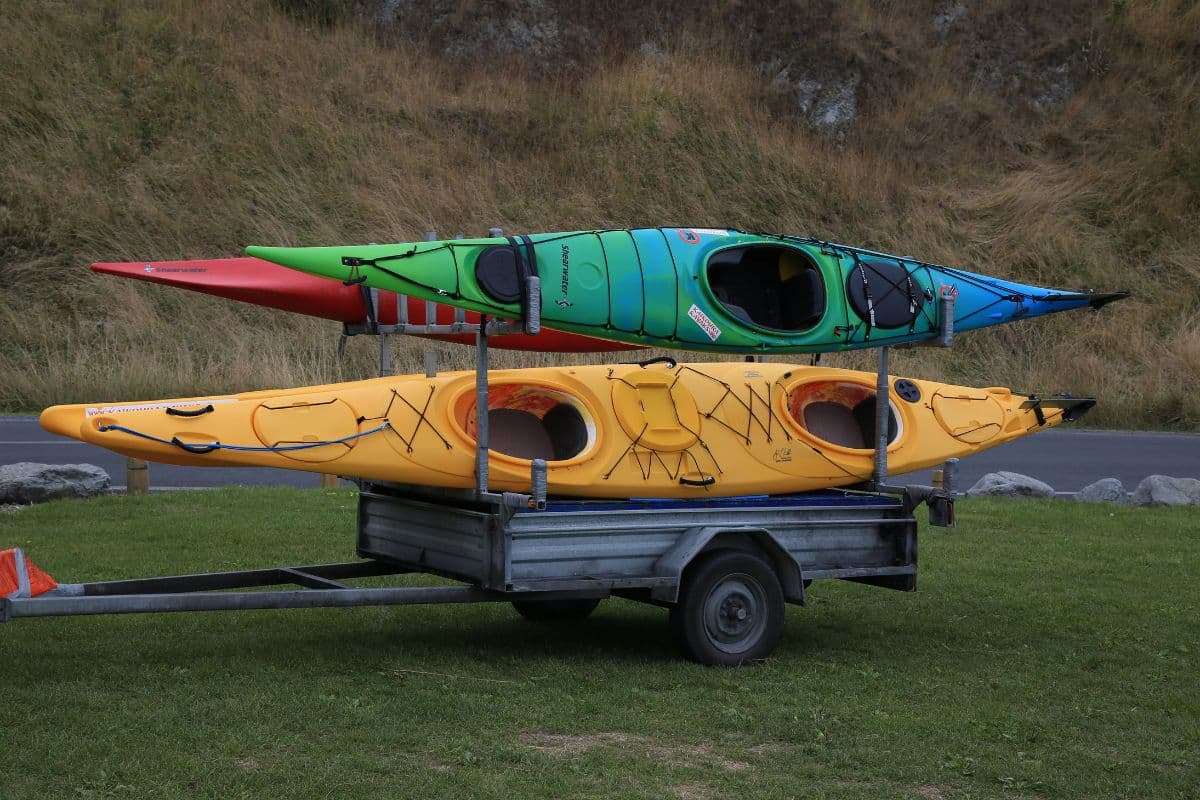 Three kayaks being transported using a kayak trailer
