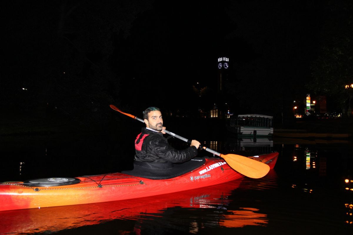 Person riding a kayak in the dark at night