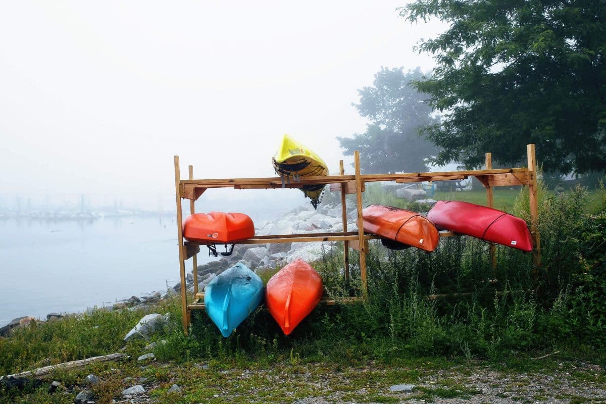 Multiple kayaks on a rack outdoors