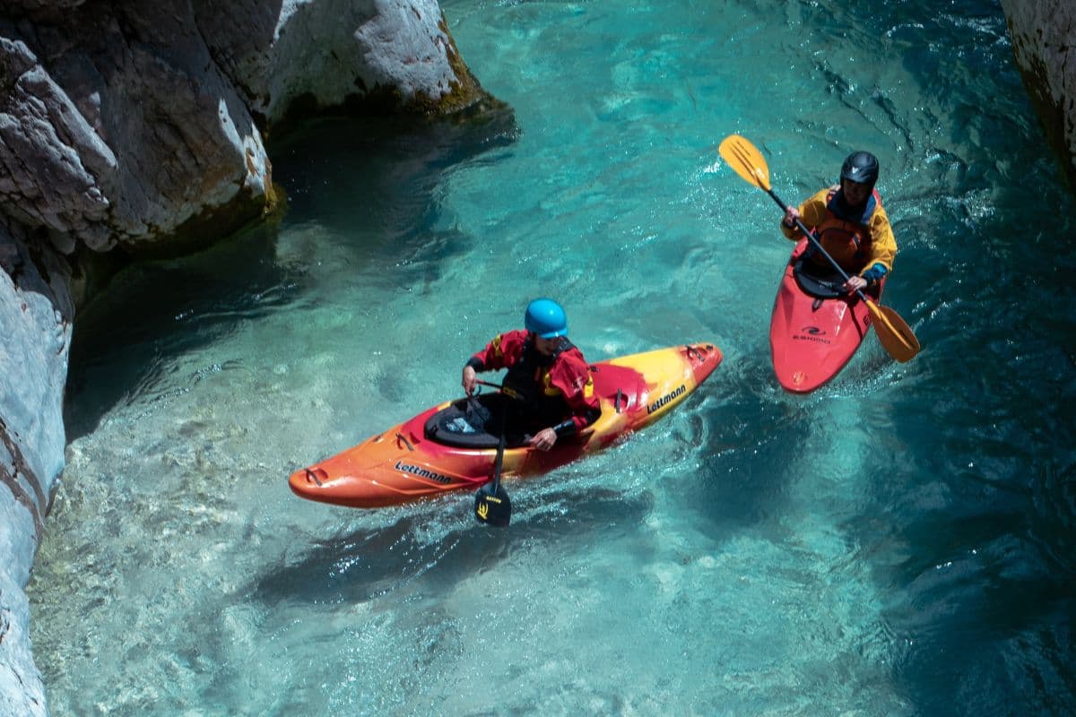 Two people riding kayaks with spray skirts