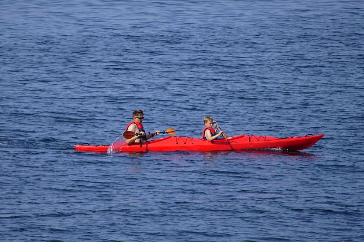 Man and child paddling on a tandem kayak together