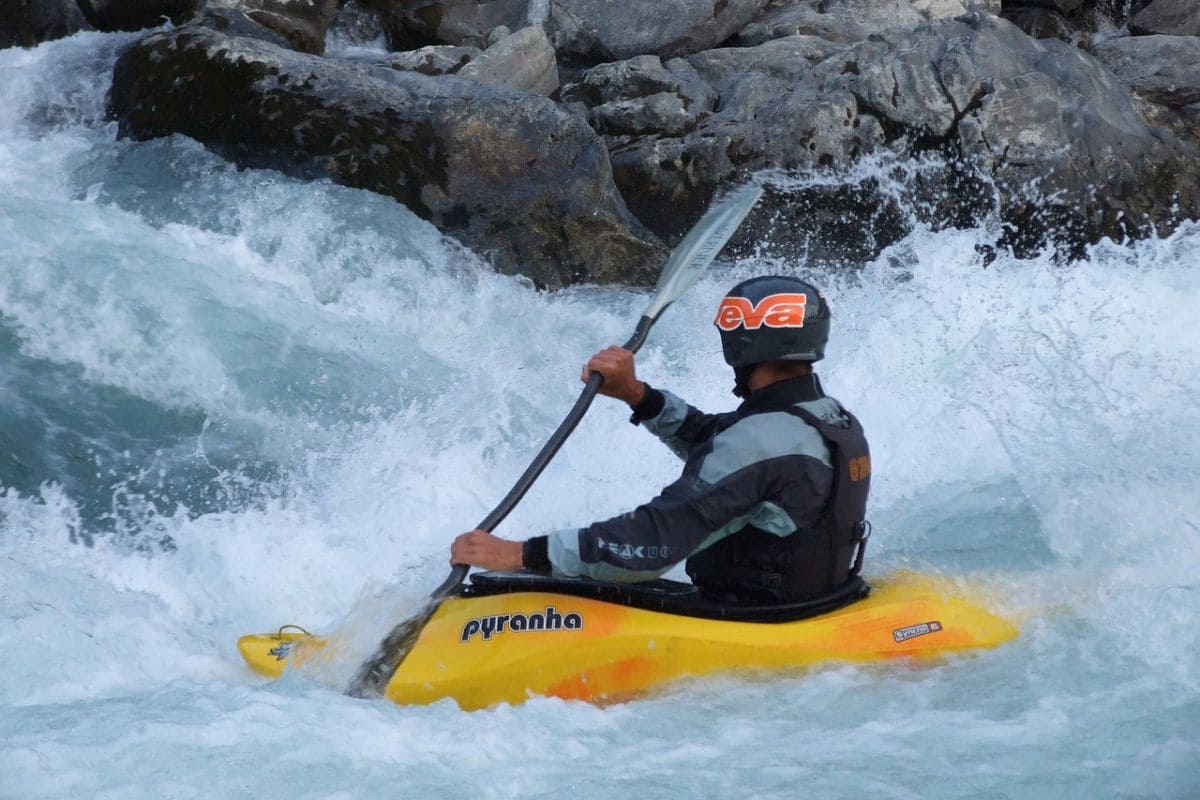 Man riding on a playboat kayak in a raging river