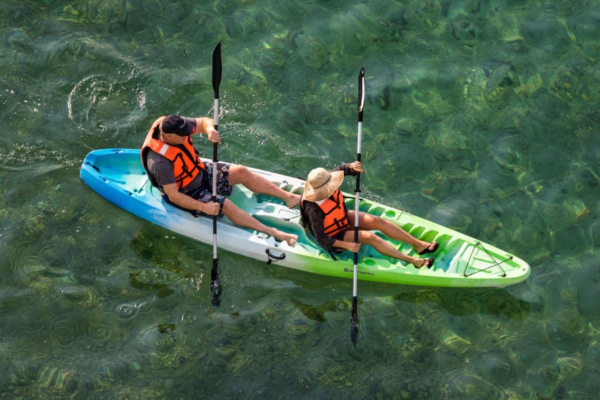 Two people riding a sit-on-top kayak