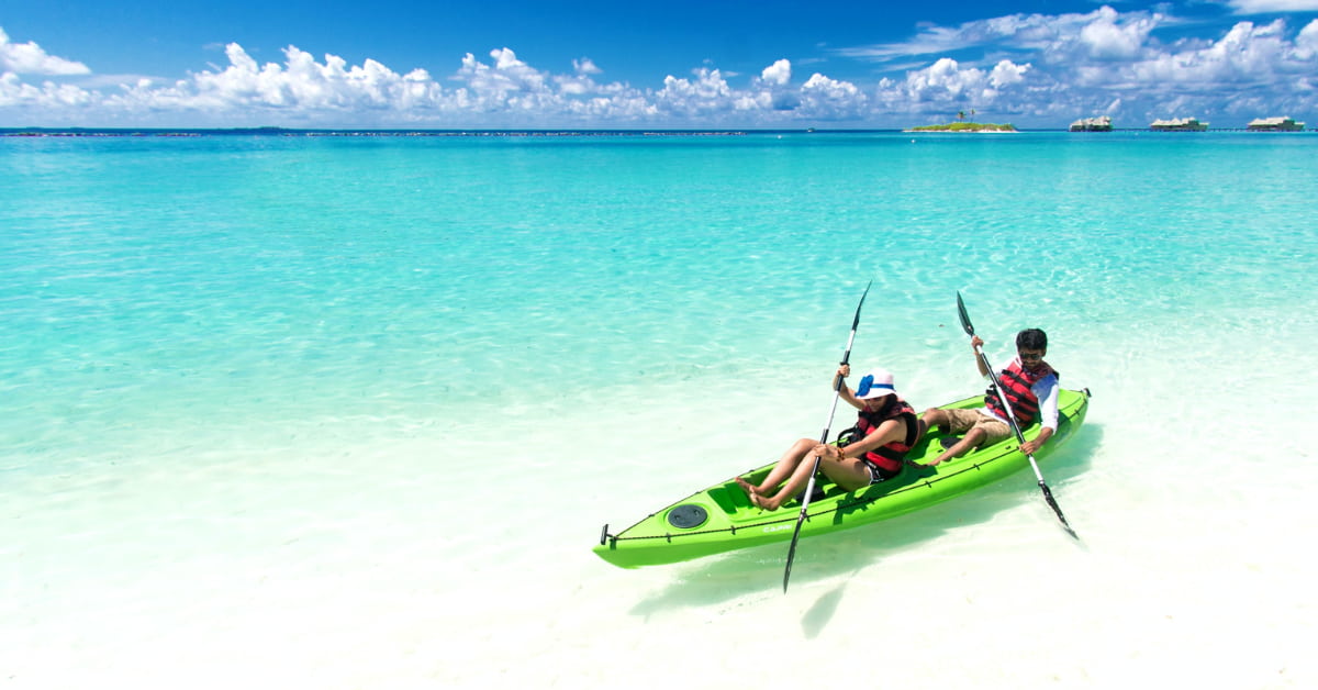 Two people on a kayak near the beach