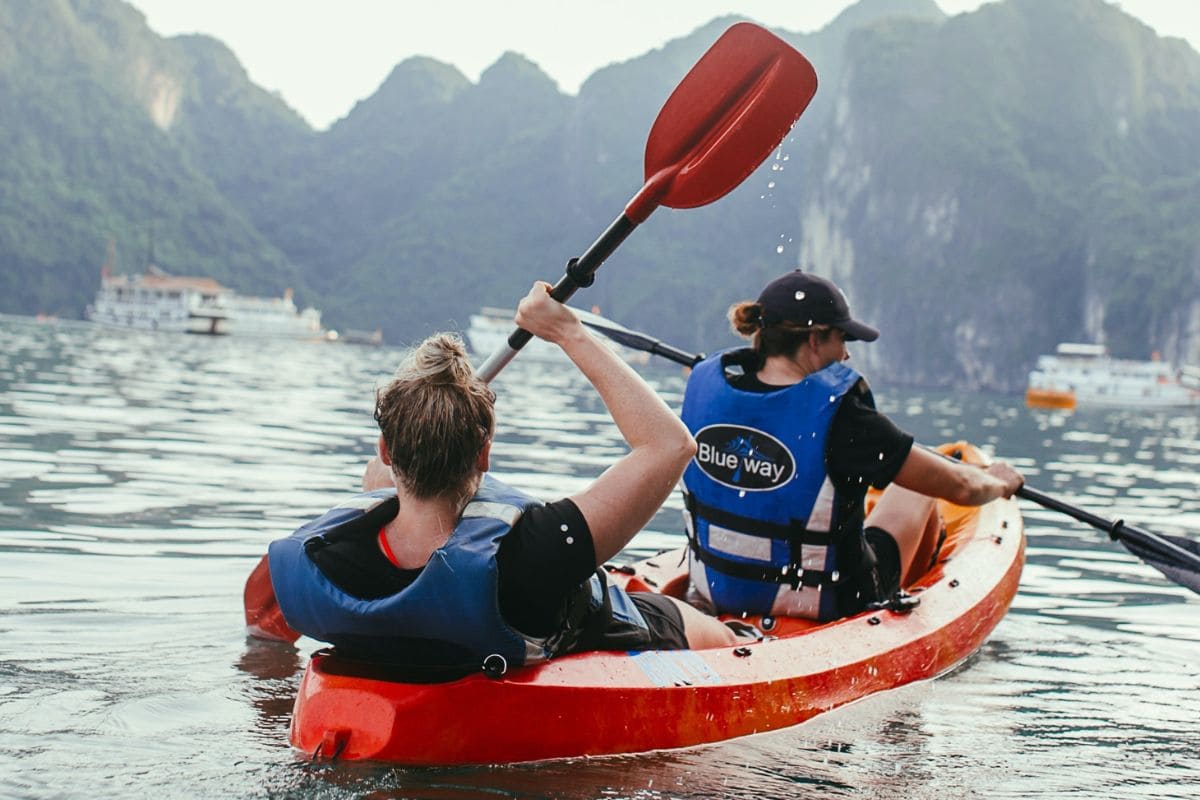 Two women paddling on a kayak in tandem